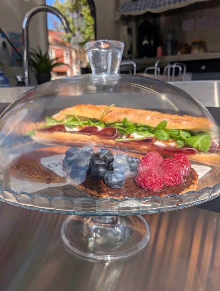 Sandwich et stroopwafel présentés sous cloche en verre sur le comptoir TIMOU